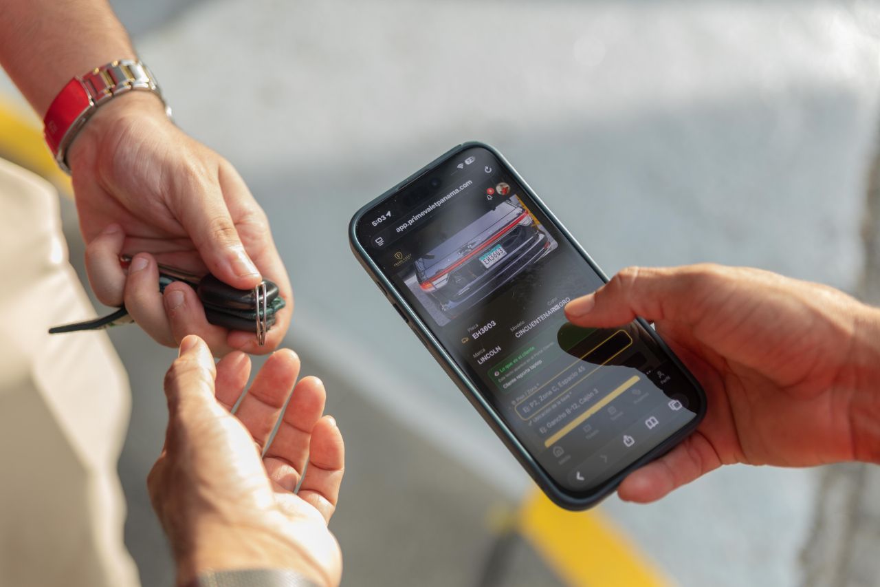Entrega de llaves del vehículo mientras se muestra el detalle en la app Prime Valet
